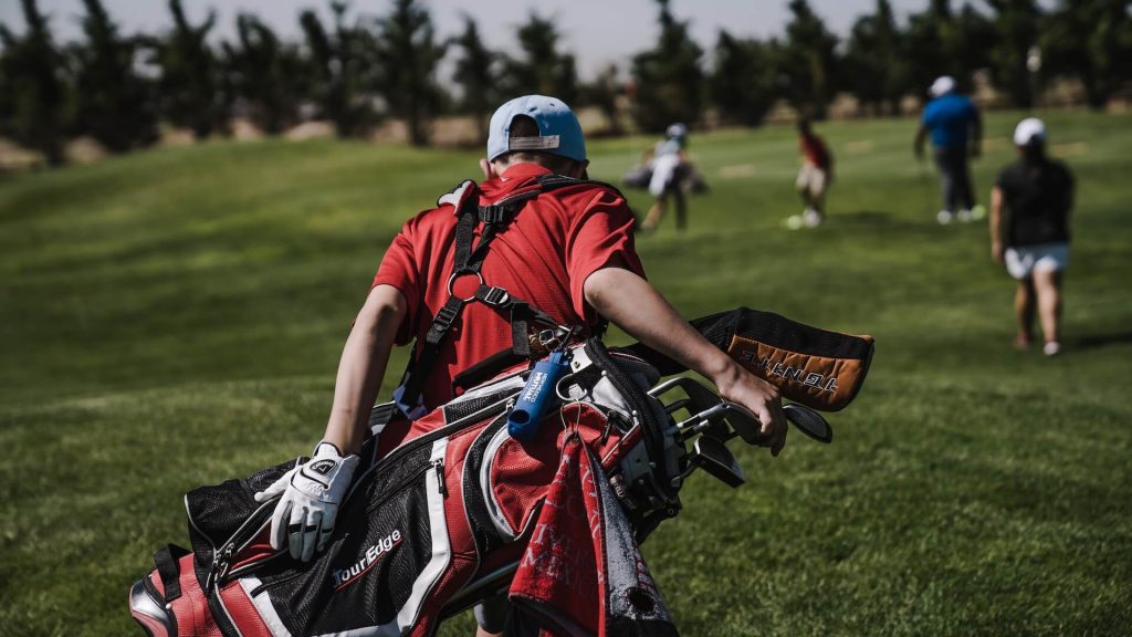 A man holding golf clubs in his hand.