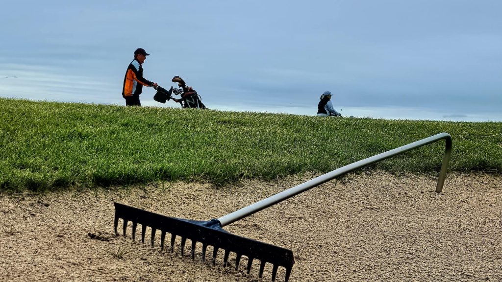 A golf course with two men playing golf.