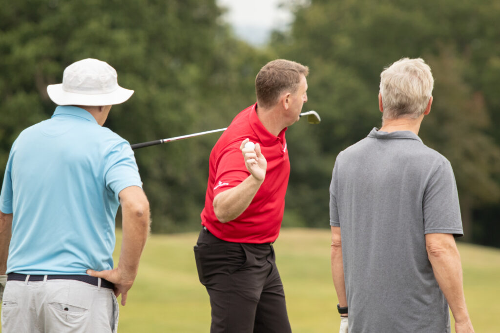 Three men on a golf course.